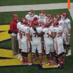 Indiana's offensive line huddles to plan blocking at Michigan Stadium. (Photo by Chris Goff.)